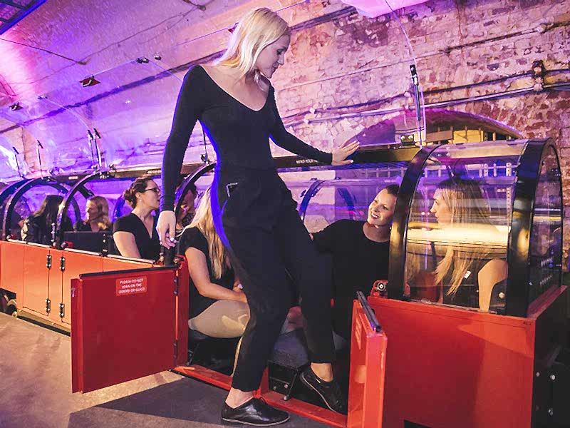 A group of visitors riding Mail Rail at a private event