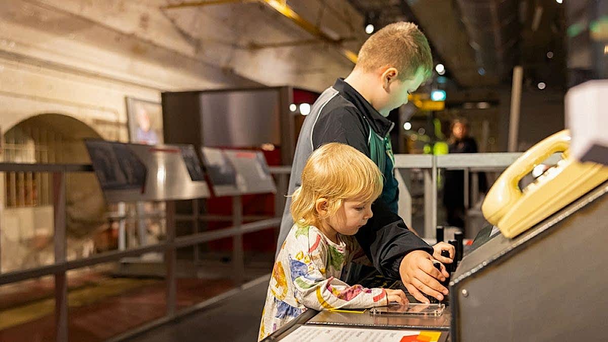 Two young children playing with an interactive exhibition.