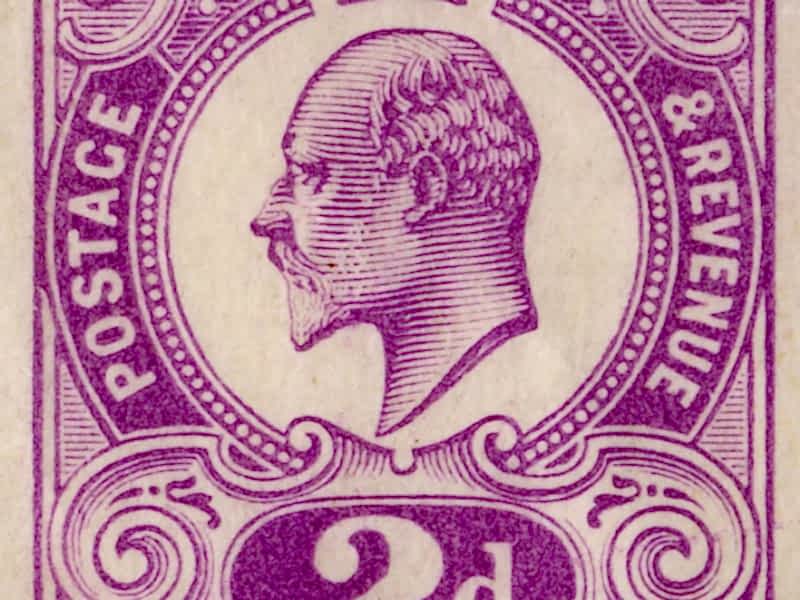 A closeup view of an individual purple stamp, with a portrait of King Edward VII in the middle with a crown, and the words 'Postage & Revenue 2d' around the portrait.