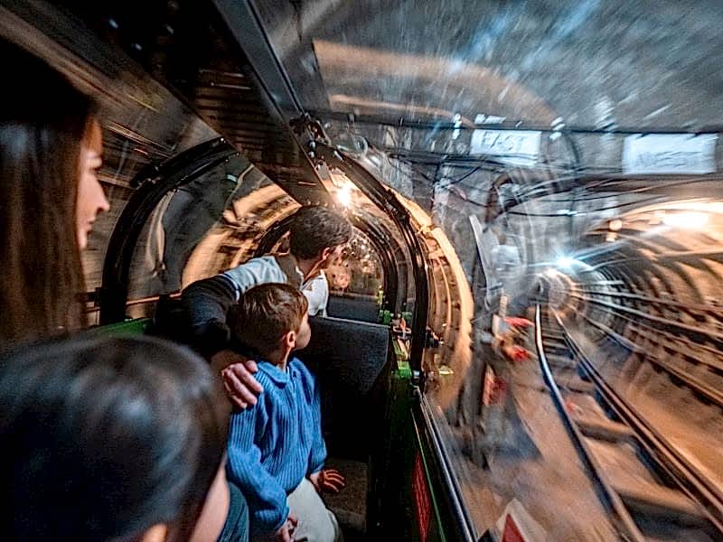 This slightly blurry image gives you a feel for the experience riding Mail Rail. The child and parent passengers look in awe at the dimly-lit Mail Rail tunnels.