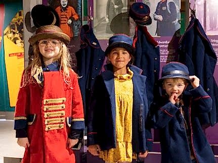 Photo of three children dressing up in postal uniforms.