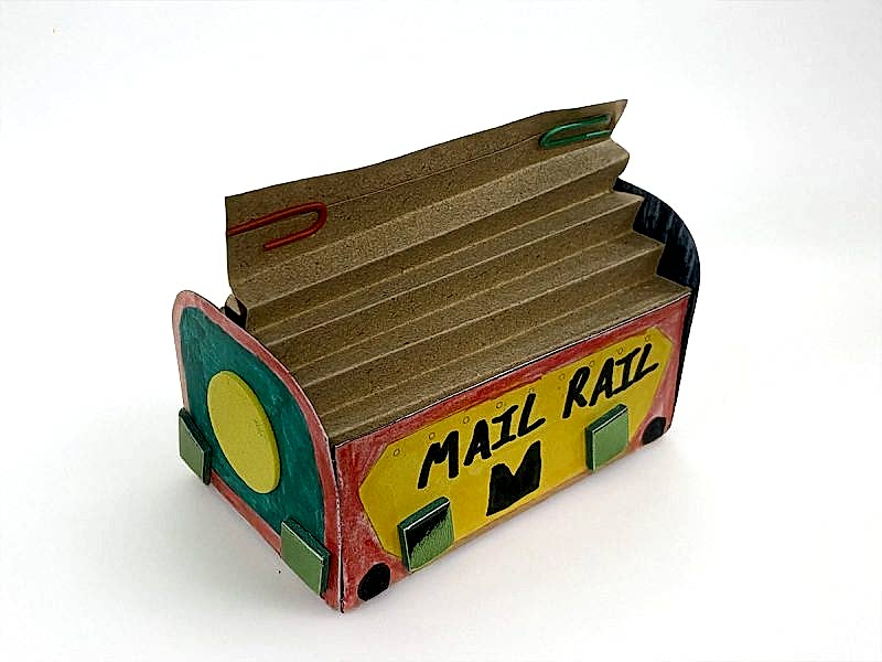 A colourful red, yellow and green paper model of a Mail Rail York trolley.